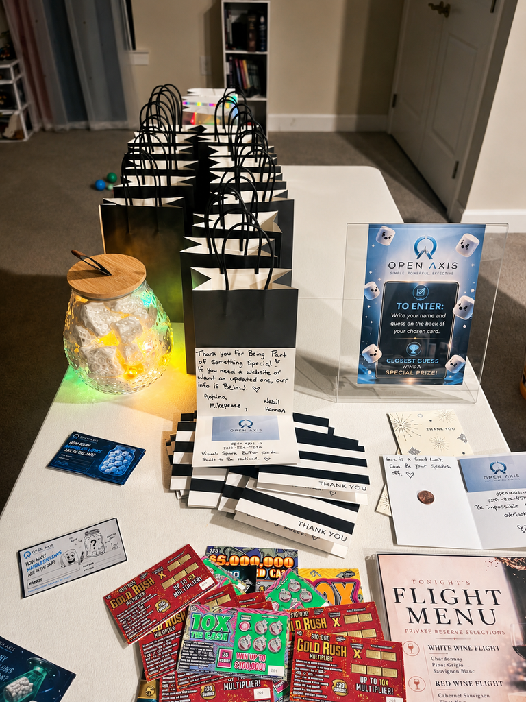 Branded OPEN ΛXIS keepsakes and prize cards laid out for guests